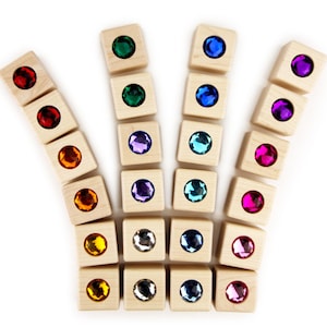 May include: A set of wooden blocks with colorful gem-like inserts. The blocks are arranged in a crown shape.