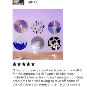 May include: A set of 6 blank CDs with different designs, including lightning bolts, flames, and cow print. The CDs are arranged in a grid on a purple background. CDS (25) For crafts or decorating, Mixed box music free shipping $10.00
