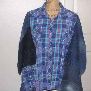 May include: A blue and turquoise plaid shirt with denim patches. The shirt has a button-up front and long sleeves.