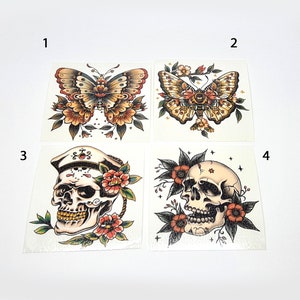 Może przedstawiać: Cztery wzory tymczasowych tatuaży. Pierwszy wzór to motyl z żółtymi i pomarańczowymi skrzydłami. Drugi wzór to motyl z brązowymi i pomarańczowymi skrzydłami. Trzeci wzór to czaszka z marynarską czapką i kwiatami. Czwarty wzór to czaszka z kwiatami.