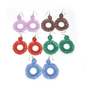May include: Set of six pairs of crocheted earrings in various colours, including purple, brown, red, green, and blue. Each earring features a circular design with a small loop at the top.