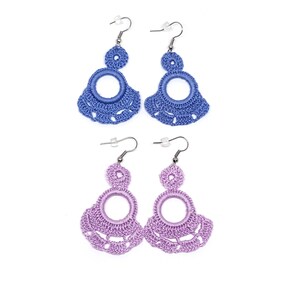 May include: A pair of blue crocheted earrings and a pair of purple crocheted earrings. Each earring has a large circle in the center and a smaller circle above it.