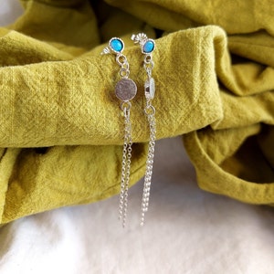 May include: A pair of silver earrings with blue opal stones and silver discs hanging from delicate chains.
