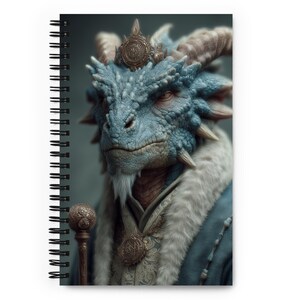 Peut inclure: Cahier à spirales avec une illustration détaillée d'un dragon bleu royal, portant une couronne et une robe bordée de fourrure. Le dragon a une barbe blanche et tient un sceptre. La couverture du cahier présente de l'art fantastique.
