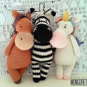 May include: Three crocheted stuffed animals: a brown horse, a black and white zebra, and a white unicorn with a rainbow mane and a yellow horn.