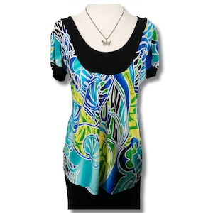May include: A blue, green, and white patterned short-sleeved top with a black scoop neck. The top has a black band around the neckline and a black skirt.