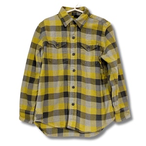 May include: Yellow, gray, and black plaid button-down shirt. The long-sleeved shirt has two chest pockets and a classic collar. The shirt is hanging on a white hanger against a white background.