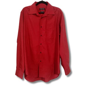 May include: A long-sleeved red button-down shirt with a single chest pocket. The shirt has a black brand label that reads "Fashion Bug" on the front.