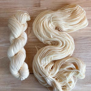 Buttermilk - Hand dyed off white wool yarn - DK/Worsted merino, DK Cashmerino, Sock, and Mohair Silk Bases. Cream, ivory, white yarn.