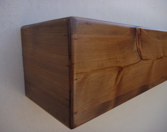 May include: A close-up of a wooden shelf, showing the natural grain of the wood and the dark brown stain. The shelf is made of solid wood and has a rustic look.