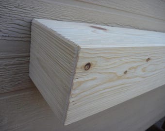 May include: A close-up of a natural wood shelf, showing the grain and knots of the wood. The shelf is unfinished and has a light brown color.