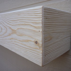 May include: A close-up of a natural wood shelf with a light wood stain. The shelf is made of solid wood and has a smooth, finished surface.