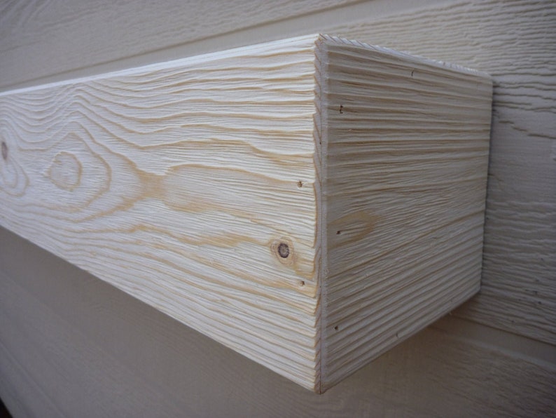 May include: A close-up of a natural wood shelf with a light wood stain. The shelf is made of solid wood and has a smooth, finished surface.