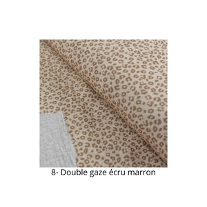 May include: Close-up of a beige fabric with a brown leopard print. The fabric is folded in half and the text "8- Double gaze ecru marron" is visible at the bottom of the image.