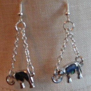 May include: Silver dangle earrings featuring a small, black enamel elephant charm on each earring.