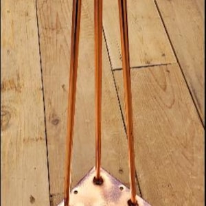 May include: Copper hairpin legs for furniture. The legs have a triangular base with a rounded top.