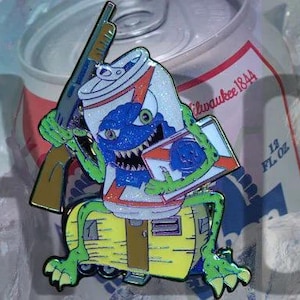 May include: A green monster holding a shotgun and a blue and white can with the text "Milwaukee 1844" and "12 FL OZ".