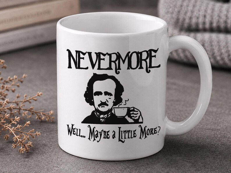 May include: A white ceramic mug featuring a black graphic illustration of Edgar Allan Poe holding a coffee cup. The text "NEVERMORE" is printed above the illustration, and the text "WELL... MAYBE A LITTLE MORE?" is printed below it.