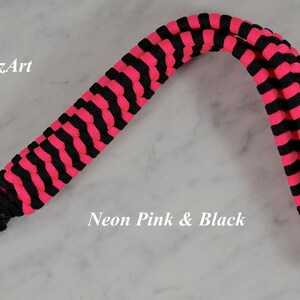 May include: A wrist lanyard crafted from neon pink and black paracord in a braided pattern, featuring a silver-toned metal swivel clasp. The text RainyDayzArt and Neon Pink & Black is visible on the image.