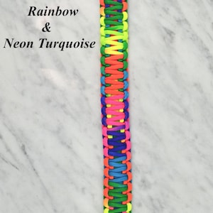 May include: A handmade lanyard in a rainbow and neon turquoise color scheme. The lanyard is made of woven cord and features a loop at the top and a decorative knot at the bottom. The text "Rainbow & Neon Turquoise" is visible.