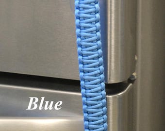 May include: A light blue paracord pull with a braided design and a spherical knot at the bottom. The text RainyDayzArt, Blue, and Large (9 inches with 5 inch loop) are visible. The cord features a loop at the top for attachment.