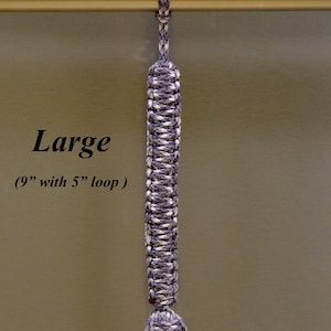 May include: A purple camo paracord lanyard featuring a braided design with a spherical knot at the bottom and a loop at the top. The text RainyDayzArt, Large, (9" with 5" loop), and Purple Camo are visible on the image of this cord accessory.