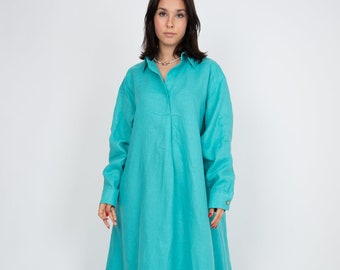 Op de afbeelding: Een vloerlange overhemdjurk met lange mouwen in een levendige turquoise kleur. Het kledingstuk is voorzien van een klassieke kraag, een verborgen knoopsluiting en manchetten met enkele knopen. De stof heeft een zichtbare weefstructuur.
