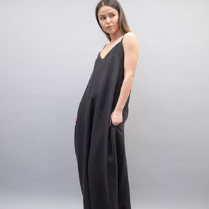 May include: A black sleeveless maxi dress with a loose, flowing fit. The dress has a simple, elegant design and is made from a soft, comfortable fabric.