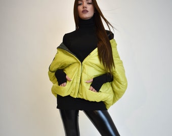 May include: A lime green puffer jacket with a black turtleneck and black leggings. The jacket has a zipper closure and a hood.
