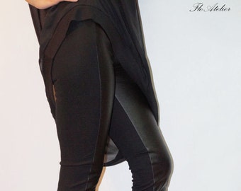 May include: Black leggings with a faux leather panel on the outside of each leg. The leggings are paired with black wedge heeled boots.