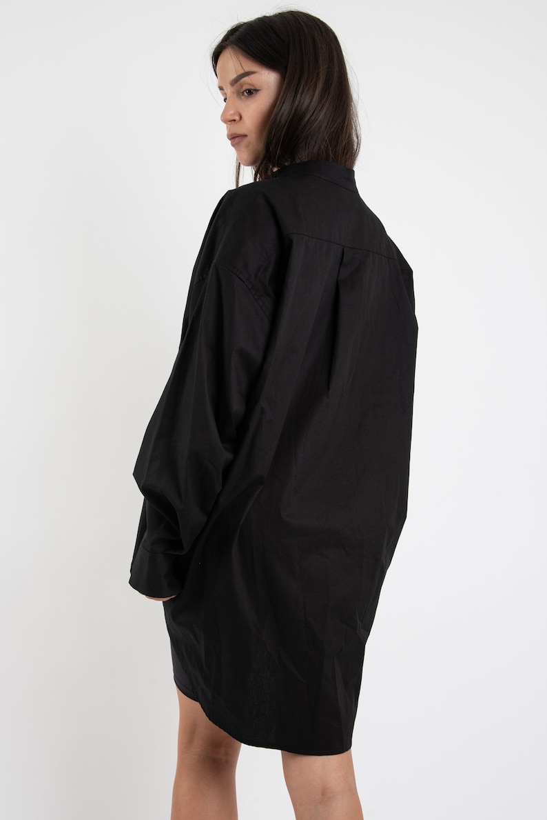 Puede incluir: Una camisa negra de gran tama&ntilde;o con cuello y mangas largas. La camisa est&aacute; hecha de una tela suave y ligera y tiene un corte holgado.