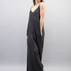 May include: A black sleeveless maxi dress with a V-neckline. The dress has a relaxed fit and is made of a soft, flowing fabric.