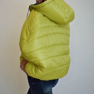 May include: A lime green puffer jacket with a hood. The jacket has a quilted design and is made of a lightweight material.