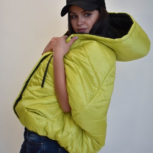 May include: A lime green puffer jacket with a black hood and a black baseball cap with the word "SURVIVOR" on it.
