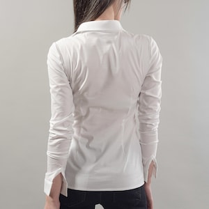 Puede incluir: Una camisa blanca de manga larga con botones, cuello cl&aacute;sico y silueta ajustada.