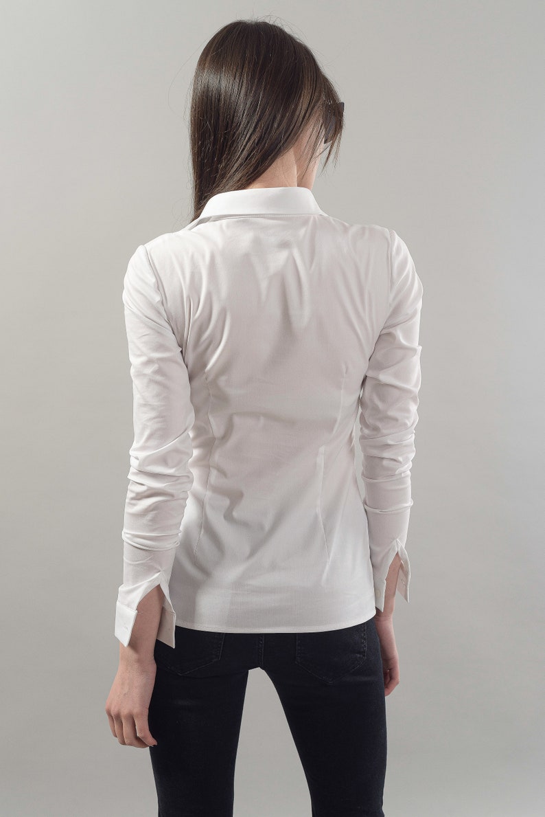Puede incluir: Una camisa blanca de manga larga con botones, cuello cl&aacute;sico y silueta ajustada.