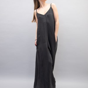 May include: A black sleeveless maxi dress with a V-neckline. The dress has a relaxed fit and is made of a soft, flowing fabric.