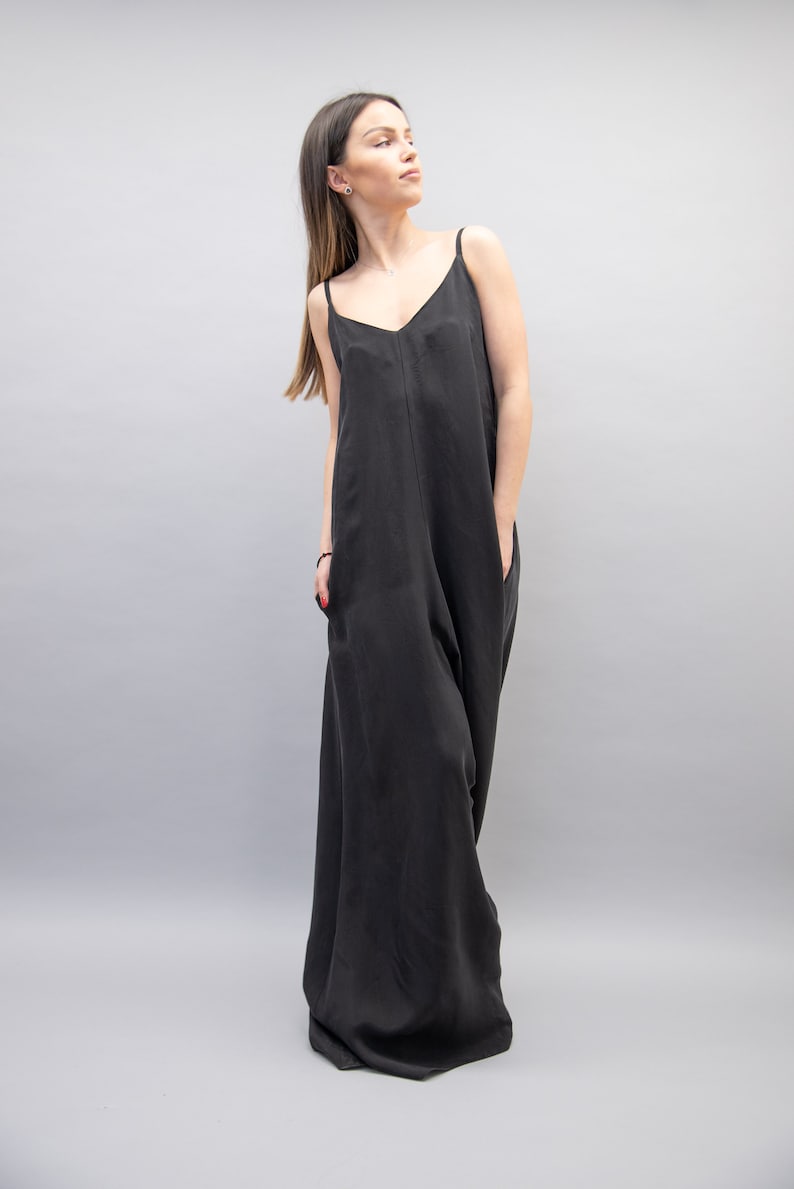 May include: A black sleeveless maxi dress with a V-neckline. The dress has a relaxed fit and is made of a soft, flowing fabric.