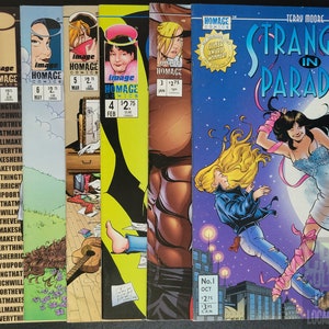 Könnte beinhalten: Eine Sammlung von Comics, darunter Ausgaben von "Strangers in Paradise" und andere Titel von Image Comics und Homage Comics. Die Cover zeigen verschiedene Illustrationen, darunter Figuren, Text und grafische Designs. Die Comics sind in einer Reihe angeordnet.