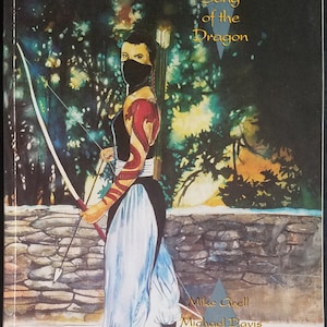 Könnte beinhalten: Comic-Cover mit einer Frau mit einem roten Drachen-Tattoo auf dem Arm, die einen Bogen und Pfeil hält. Der Titel des Comics lautet "SHADO: Song of the Dragon".