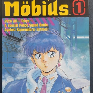 Puede incluir: Una portada de cómic con una mujer de cabello azul y un uniforme azul. El título del cómic es "Silent Möbius" y el número de la edición es "1". El texto "2026 AD - Tokyo - A special Police Squad Battle Against Supernatural Entities!" también está en la portada.