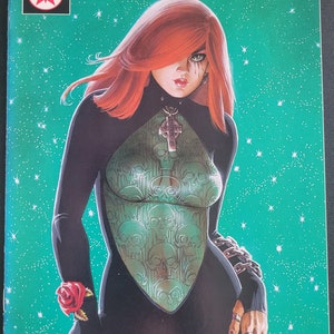 May include: A comic book cover featuring a woman with red hair wearing a black and green outfit with a skull pattern. The cover is titled "Dawn" and has the words "Wizard Genesis Edition" at the top.