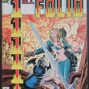 May include: A comic book cover featuring a woman in a blue and white dress holding a sword. The woman is standing in front of a man with a blue and black helmet. The background is a red and yellow flame-like design. The title of the comic is "1st Folio" and the cover is from "The Joe Kuber School Presents".