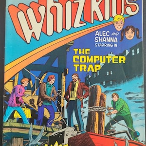 Könnte beinhalten: Ein Comic-Cover mit dem Titel "Whiz Kids" in großen, bunten Buchstaben. Das Cover zeigt eine Gruppe von Figuren, die auf einem Dock stehen, mit einem roten Boot im Wasser. Der Text "The Computer Trap" ist unter dem Titel zu sehen, zusammen mit den Namen "Alec und Shanna" und den Worten "Starring In". Der Comic wird als "TRS-80 Computer"-Produkt beworben und trägt das Logo von Radio Shack.