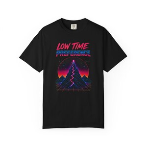 May include: A black short-sleeve t-shirt featuring a graphic print with the text "LOW TIME PREFERENCE" in pink and blue. The design depicts a stylized mountain peak with a glowing pink lightning bolt, a sunset, and a grid pattern in retro colors.