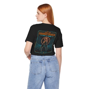 May include: A black short-sleeve t-shirt featuring a graphic on the back with the text JOIN THE RESISTANCE RUN A NODE. The design includes an orange Bitcoin symbol, a silhouette of a person, and a blue grid pattern on a dark background.
