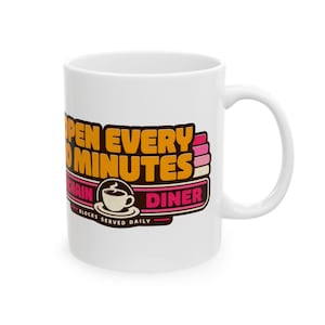 May include: A white ceramic mug featuring a graphic design with the text OPEN EVERY 10 MINUTES, CHAIN DINER, and BLOCKS SERVED DAILY. The design includes a stylized coffee cup icon in brown, orange, and pink colors on a white background.