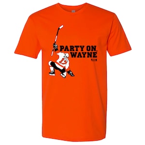 May include: Bright orange t-shirt featuring a hockey player graphic in black, white, and orange. The text "PARTY ON, WAYNE" is printed in black. The shirt is a crew neck style.