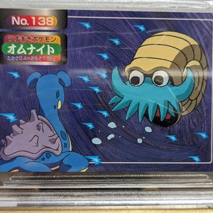 May include: A blue and purple Pokemon card featuring the Pokemon Omanyte. The card is numbered No. 138 and has the Japanese text "Omanyte" and "高さ0.4m重さ7.5kg".
