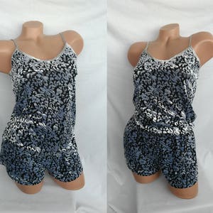 May include: A black and white patterned sleepwear set with a tank top and shorts. The fabric has a soft, velvety texture.